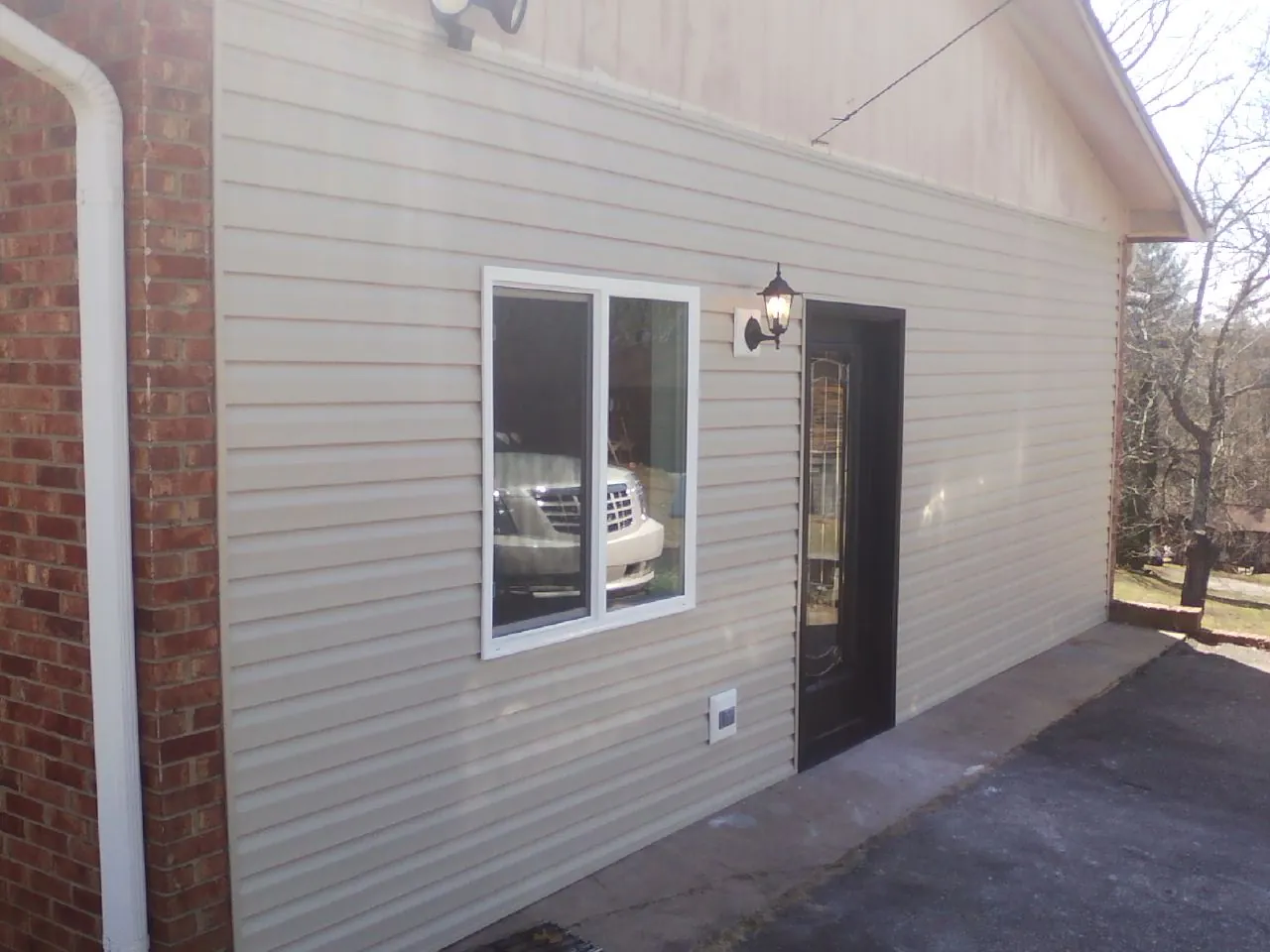 New vinyl siding and entry door on a room addition in Hudson